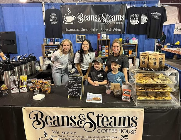 Beans and Steams Coffee House booth with custom printed shirts and a banner