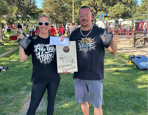 Cornhole champions with a custom engraved Dalton Fall Festival 2025 award board